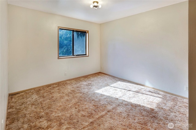 unfurnished room featuring carpet and baseboards