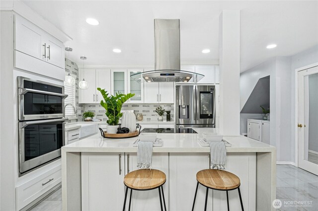 kitchen with marble finish floor, tasteful backsplash, white cabinetry, stainless steel appliances, and island range hood