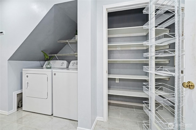 washroom featuring tile patterned floors, baseboards, separate washer and dryer, and laundry area