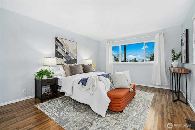 bedroom with dark wood finished floors, visible vents, and baseboards