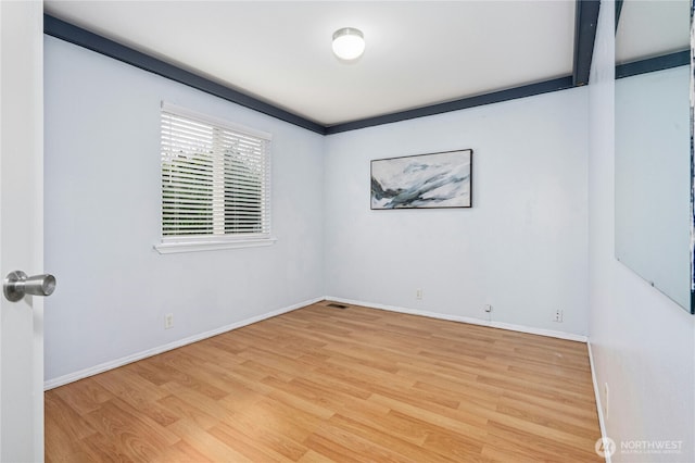 spare room featuring light wood finished floors and baseboards