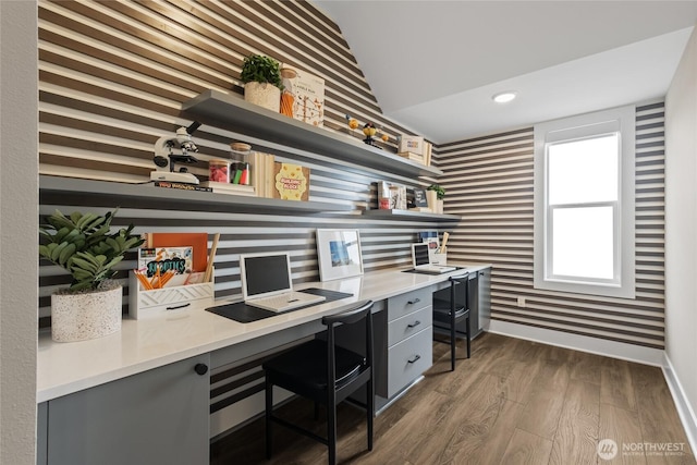 office area with dark wood finished floors, recessed lighting, built in study area, baseboards, and wallpapered walls