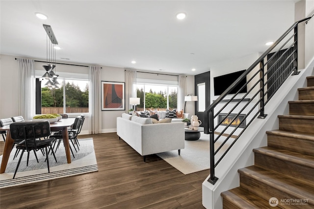 living room featuring dark wood-type flooring, recessed lighting, stairway, and baseboards