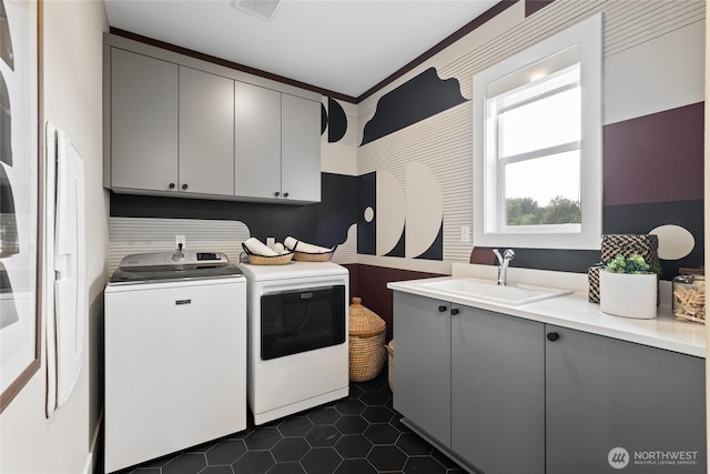 laundry area with cabinet space, visible vents, dark tile patterned floors, separate washer and dryer, and a sink