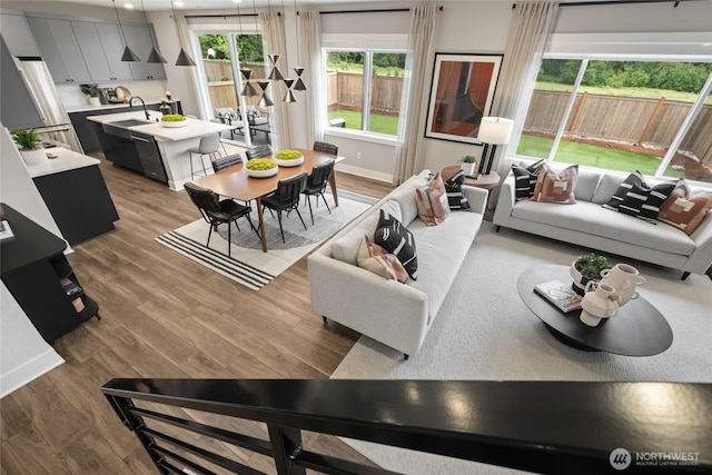 living area with baseboards and wood finished floors