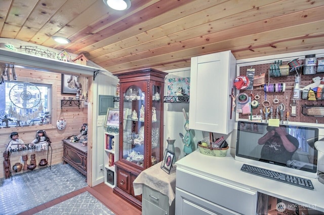 kitchen featuring wooden walls, vaulted ceiling, light countertops, wood ceiling, and white cabinetry