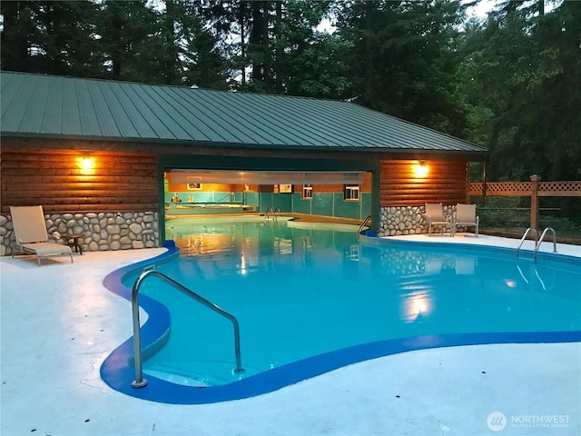 view of swimming pool featuring an outdoor structure, fence, a fenced in pool, and a patio