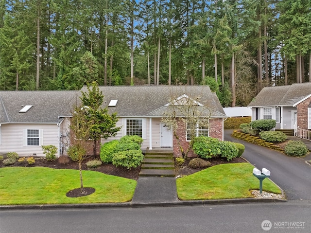 view of front of house with brick siding and a front lawn