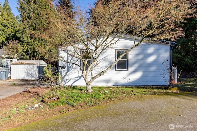 view of home's exterior with a storage unit and an outbuilding