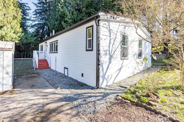 view of property exterior featuring an outbuilding and fence