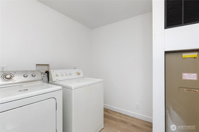 laundry room with laundry area, visible vents, baseboards, light wood-style flooring, and washing machine and dryer