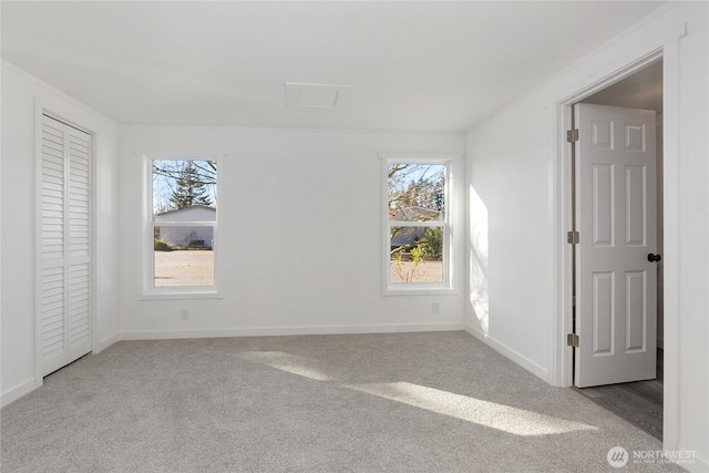 carpeted empty room featuring baseboards