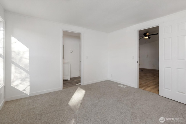 carpeted empty room featuring baseboards