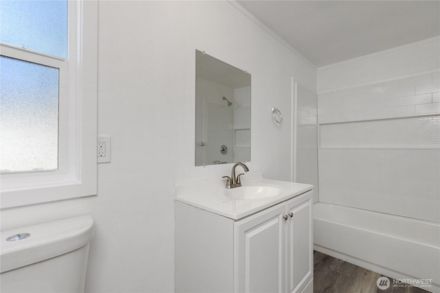 full bath with toilet, shower / bath combination, wood finished floors, and vanity