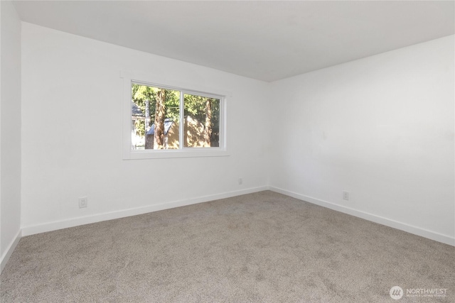 carpeted spare room featuring baseboards