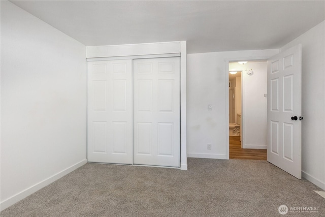 unfurnished bedroom with carpet floors, a closet, and baseboards