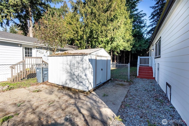 view of yard with a storage shed, fence, and an outbuilding