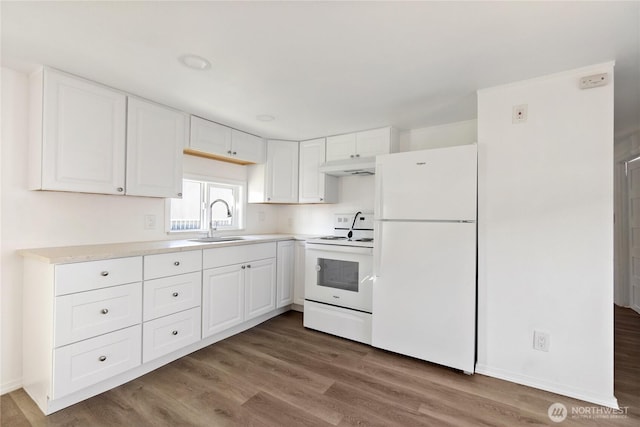 kitchen with white cabinets, a sink, wood finished floors, white appliances, and under cabinet range hood