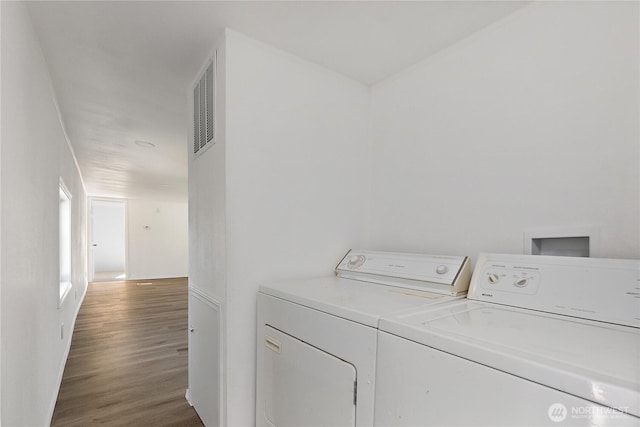 laundry area featuring wood finished floors, washing machine and dryer, and visible vents