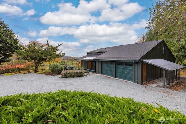 view of front facade featuring a garage, gravel driveway, roof with shingles, and metal roof