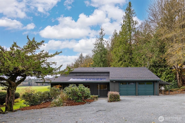 view of front facade featuring a garage, driveway, roof with shingles, and board and batten siding