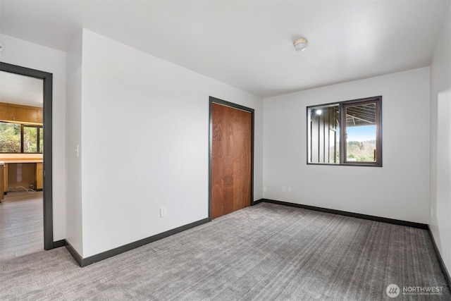 empty room with carpet and baseboards