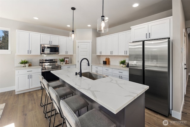 kitchen with appliances with stainless steel finishes, white cabinets, and a sink