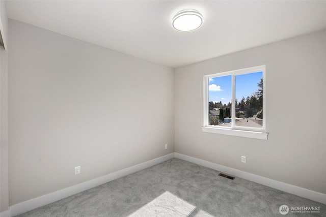 carpeted spare room with visible vents and baseboards