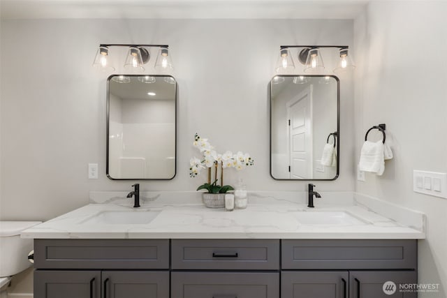 full bath featuring a sink, toilet, and double vanity