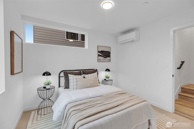 bedroom with an AC wall unit, light colored carpet, and baseboards