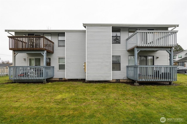 back of property with a yard, crawl space, and a balcony