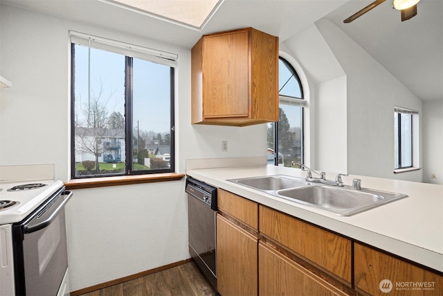 kitchen with black dishwasher, electric range oven, light countertops, and a sink