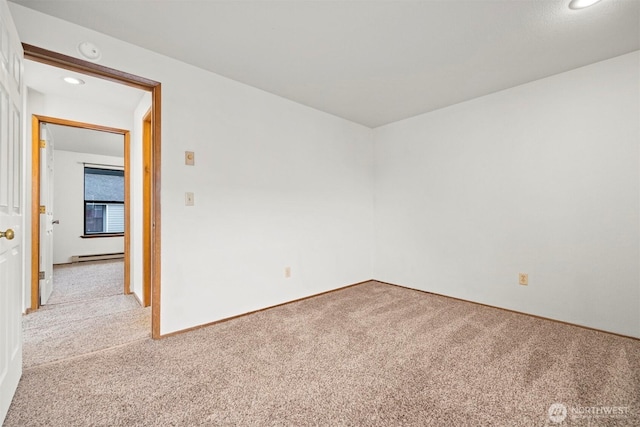 empty room with a baseboard radiator, light carpet, and recessed lighting