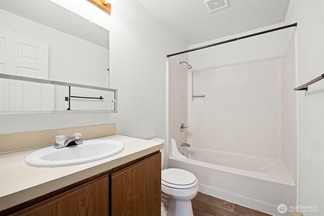 bathroom with visible vents, toilet, wood finished floors, bathtub / shower combination, and vanity