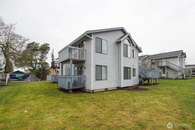 rear view of property featuring stairs, a yard, and a balcony