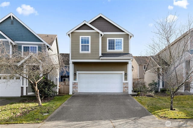 view of front facade featuring stone siding, driveway, and an attached garage