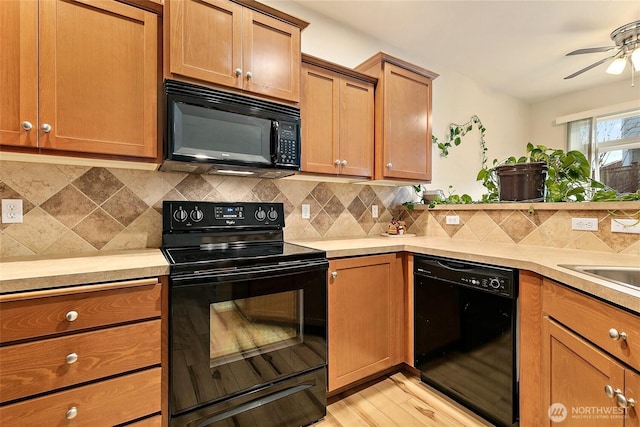 kitchen with black appliances, light countertops, and backsplash