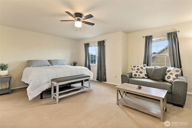 bedroom featuring light carpet, multiple windows, a ceiling fan, and baseboards