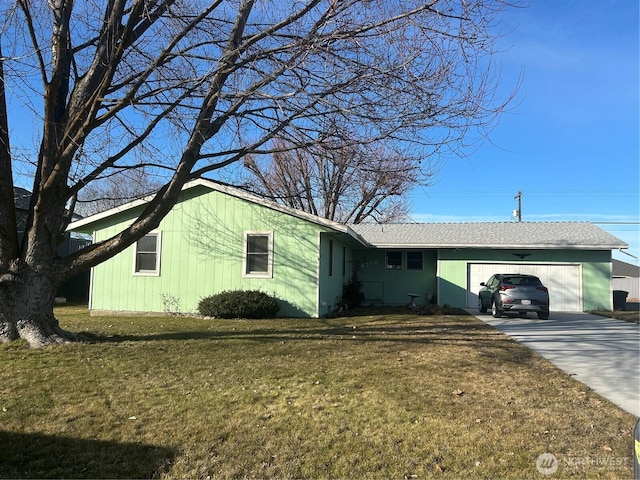 ranch-style home featuring a garage, driveway, and a front lawn