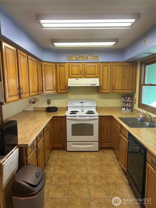 kitchen with under cabinet range hood, a sink, light countertops, black appliances, and brown cabinetry