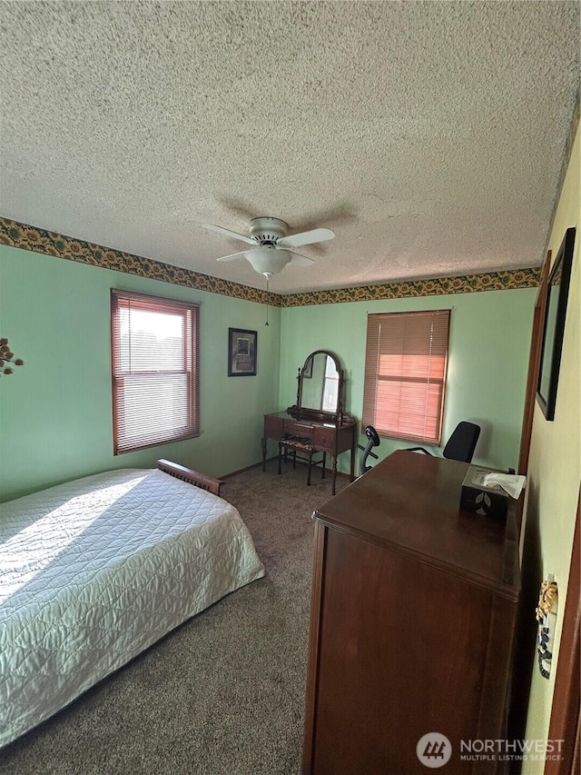 bedroom with carpet, ceiling fan, and a textured ceiling