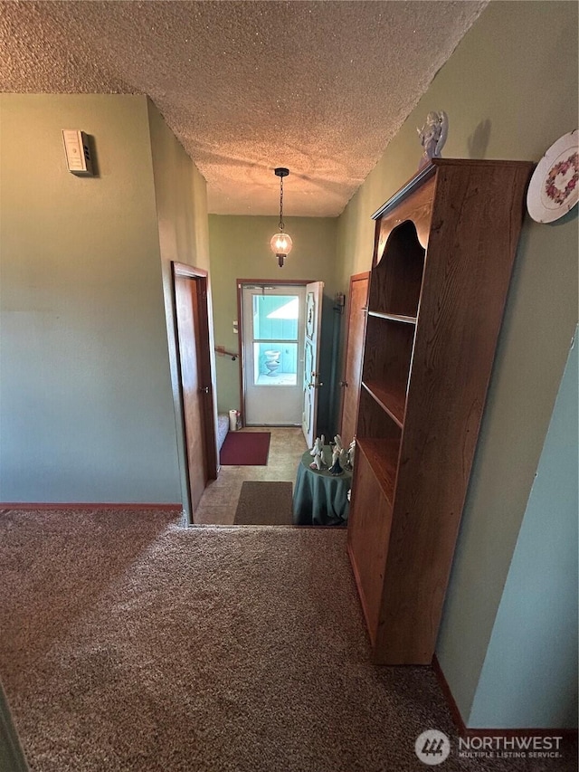 hall with a textured ceiling and carpet