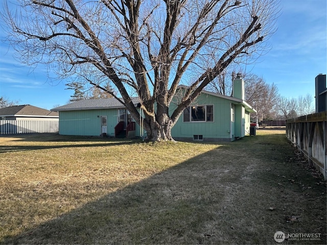 back of house with a lawn, a chimney, and fence private yard