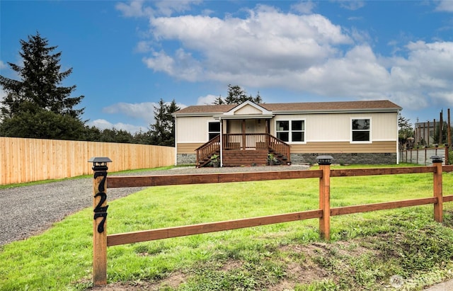 manufactured / mobile home featuring a front yard, crawl space, and fence