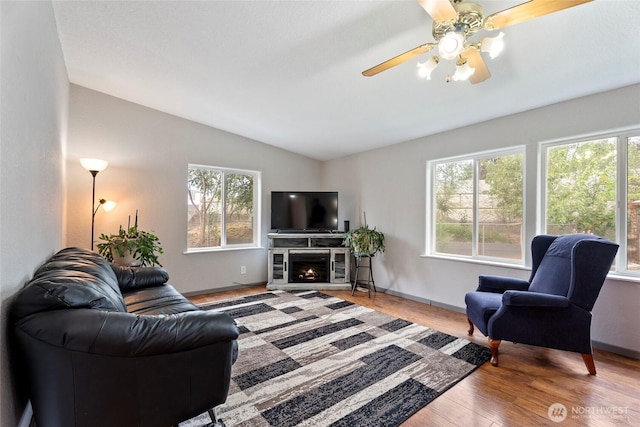 living area featuring vaulted ceiling, plenty of natural light, and wood finished floors