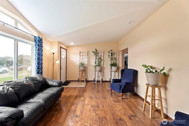 living area with lofted ceiling, wood finished floors, and baseboards