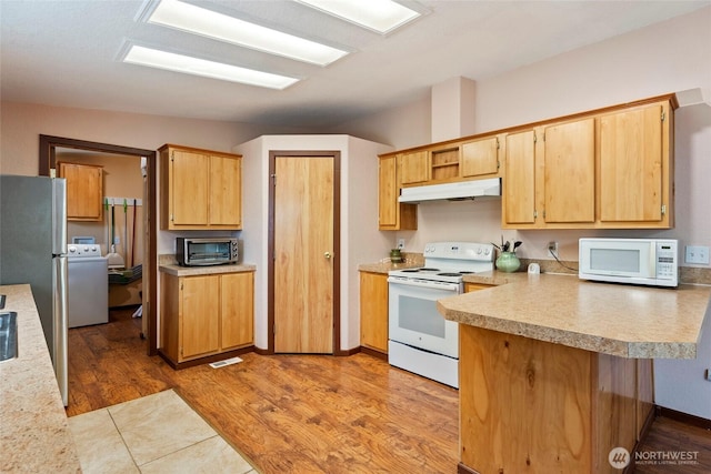 kitchen featuring washer / clothes dryer, white appliances, light countertops, and under cabinet range hood