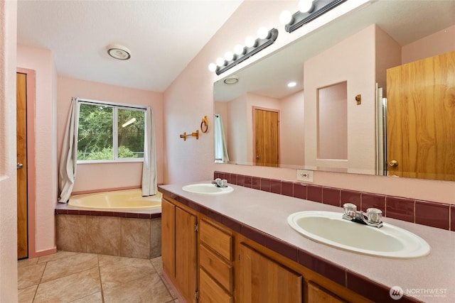 bathroom featuring a relaxing tiled tub, double vanity, a sink, and tile patterned floors