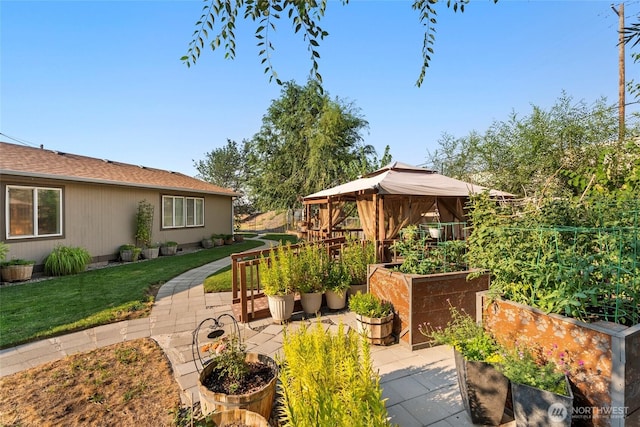 view of patio with a garden and a gazebo