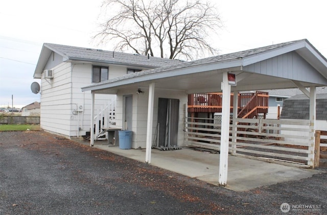 view of front of home featuring stairway and roof with shingles